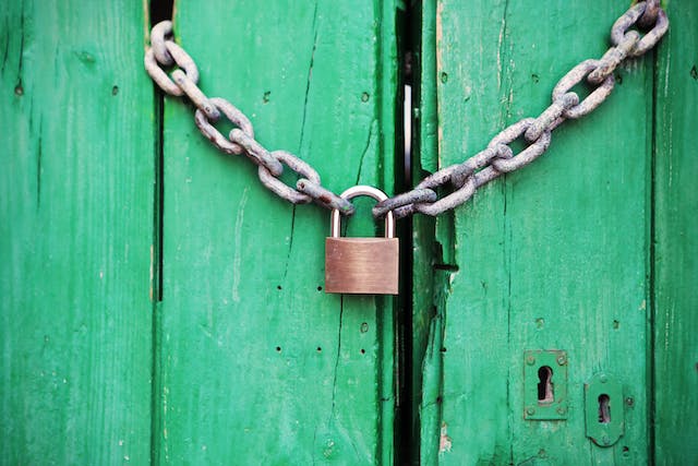 A padlock securing a door shut.