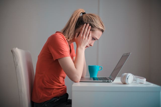 A person looking stressed at their laptop