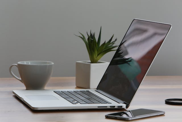 A laptop and a phone on a table.