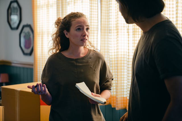 A couple having a discussion in front of some moving boxes.